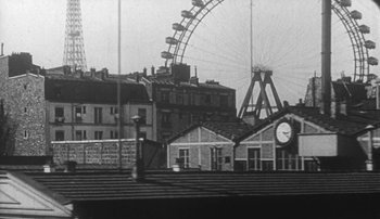 Movie still from “Jules and Jim” (1962), directed by François Truffaut – An old photo of a ferris wheel in the background; Extreme Wide shot, Low angle