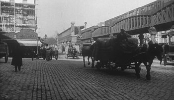 Movie still from “Jules and Jim” (1962), directed by François Truffaut – A black and white photo of a street scene with cows; Wide shot, Low angle