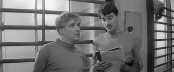 Movie still from “Jules and Jim” (1962), directed by François Truffaut – Two men looking at a cell phone in a room; Close Up shot, Over the shoulder angle