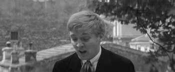 Movie still from “Jules and Jim” (1962), directed by François Truffaut – Black and white photograph of a man in a suit and tie; Close Up shot, High angle