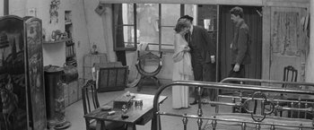 Movie still from “Jules and Jim” (1962), directed by François Truffaut – A man and a woman kissing in a room; Wide shot, High angle