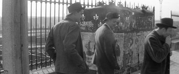 Movie still from “Jules and Jim” (1962), directed by François Truffaut – A couple of men standing next to each other near a fence; Medium shot, Low angle