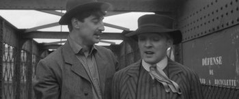Movie still from “Jules and Jim” (1962), directed by François Truffaut – A black and white photo of two men in suits and hats; Close Up shot, Over the shoulder angle