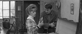 Movie still from “Jules and Jim” (1962), directed by François Truffaut – An old photo of a woman and a man looking at a bottle; Medium shot, Over the shoulder angle
