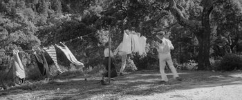 Movie still from “Jules and Jim” (1962), directed by François Truffaut – A man and a woman hanging clothes on a clothesline; Wide shot, Low angle