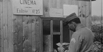Movie still from “Jules and Jim” (1962), directed by François Truffaut – An old black and white photo of a soldier looking at a piece of paper; Medium shot, Low angle