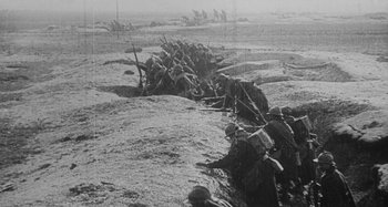 Movie still from “Jules and Jim” (1962), directed by François Truffaut – A group of men are standing in the dirt; Extreme Wide shot, High angle