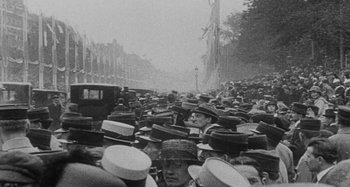 Movie still from “Jules and Jim” (1962), directed by François Truffaut – A large group of people are gathered in a street; Medium shot, High angle