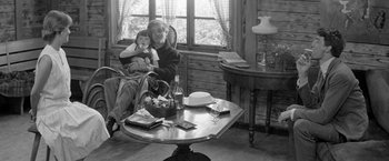 Movie still from “Jules and Jim” (1962), directed by François Truffaut – An older woman sitting in a chair holding a child; Medium shot, High angle