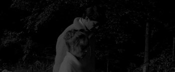 Movie still from “Jules and Jim” (1962), directed by François Truffaut – A man and a woman standing next to each other in front of a tree; Medium shot, High angle