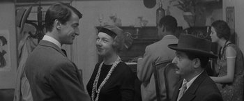 Movie still from “Jules and Jim” (1962), directed by François Truffaut – An old photo of a man and a woman at a party; Medium shot, Over the shoulder angle