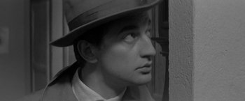 Movie still from “Jules and Jim” (1962), directed by François Truffaut – A black and white photo of a man wearing a hat; Close Up shot, High angle