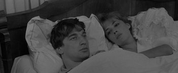 Movie still from “Jules and Jim” (1962), directed by François Truffaut – A man and a woman laying in a bed together; Close Up shot, High angle
