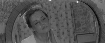 Movie still from “Jules and Jim” (1962), directed by François Truffaut – A black - and - white photo of a woman looking in a mirror; Close Up shot, High angle