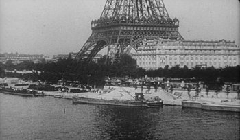 Movie still from “Jules and Jim” (1962), directed by François Truffaut – A black - and - white photo of the eiffel tower in paris; Extreme Wide shot, High angle