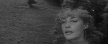 Movie still from “Jules and Jim” (1962), directed by François Truffaut – Black and white photograph of a woman's face in front of trees; Close Up shot, High angle