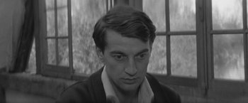 Movie still from “Jules and Jim” (1962), directed by François Truffaut – A black - and - white photo of a man looking at the camera; Close Up shot, High angle