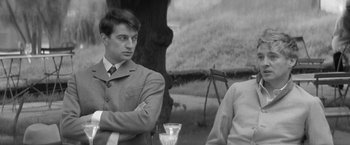 Movie still from “Jules and Jim” (1962), directed by François Truffaut – A man sitting next to another man at a table; Medium shot, Over the shoulder angle