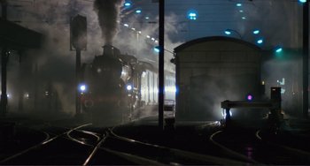 Movie still from “Julia” (1977), directed by Fred Zinnemann – A steam train is coming down the tracks at night; Extreme Wide shot, High angle