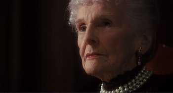 Movie still from “Julia” (1977), directed by Fred Zinnemann – An older woman wearing a black dress and pearls; Close Up shot, Low angle