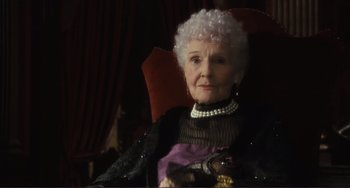Movie still from “Julia” (1977), directed by Fred Zinnemann – An older woman sitting in a chair wearing a dress; Close Up shot, Low angle