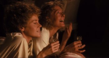 Movie still from “Julia” (1977), directed by Fred Zinnemann – Two women sitting next to each other holding wine glasses; Close Up shot, High angle