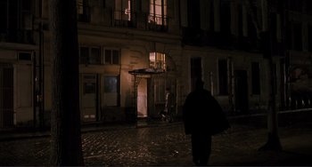 Movie still from “Julia” (1977), directed by Fred Zinnemann – A person walking down a street at night; Extreme Wide shot, High angle