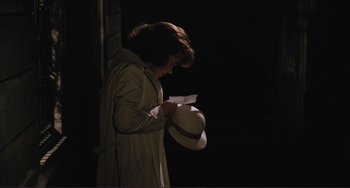 Movie still from “Julia” (1977), directed by Fred Zinnemann – A woman in a trench coat and a white hat; Medium shot, High angle