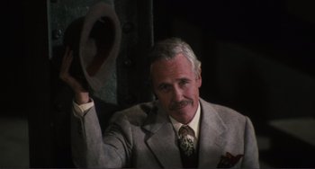 Movie still from “Julia” (1977), directed by Fred Zinnemann – An older man wearing a suit and tie holding a hat; Close Up shot, Low angle