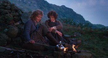 Movie still from “Julia” (1977), directed by Fred Zinnemann – Two women sitting next to each other near a campfire; Wide shot, High angle