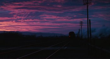 Movie still from “Julia” (1977), directed by Fred Zinnemann – A train on a train track during a purple sunset; Extreme Wide shot, Low angle