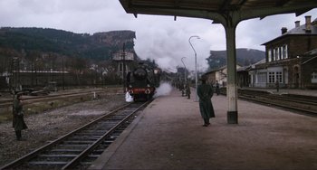 Movie still from “Julia” (1977), directed by Fred Zinnemann – A train is coming down the tracks at a train station; Extreme Wide shot, High angle