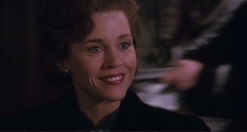 Movie still from “Julia” (1977), directed by Fred Zinnemann – A person wearing a suit and smiling; Close Up shot, Over the shoulder angle