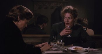 Movie still from “Julia” (1977), directed by Fred Zinnemann – Two people sitting at a table with a glass of red wine; Medium shot, Over the shoulder angle