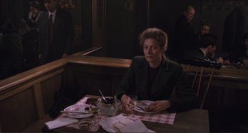 Movie still from “Julia” (1977), directed by Fred Zinnemann – A woman sitting at a table with a plate in front of her; Medium shot, High angle