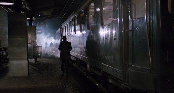 Movie still from “Julia” (1977), directed by Fred Zinnemann – A man walking on a platform next to a train; Wide shot, High angle