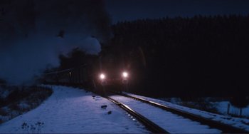 Movie still from “Julia” (1977), directed by Fred Zinnemann – A train traveling down train tracks in the snow; Extreme Wide shot, High angle