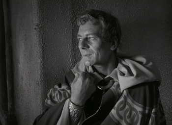 Movie still from “Julius Caesar” (1953), directed by Joseph L. Mankiewicz – A black - and - white photo of a man holding his tie; Close Up shot, Low angle