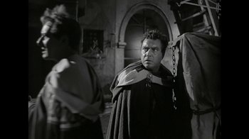 Movie still from “Julius Caesar” (1953), directed by Joseph L. Mankiewicz – A man wearing a cape and a chain around his neck; Medium shot, Over the shoulder angle