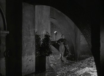 Movie still from “Julius Caesar” (1953), directed by Joseph L. Mankiewicz – A man holding a lantern in a dark place; Wide shot, High angle
