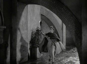 Movie still from “Julius Caesar” (1953), directed by Joseph L. Mankiewicz – A man holding a baseball bat while standing in an archway; Wide shot, High angle