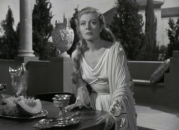 Movie still from “Julius Caesar” (1953), directed by Joseph L. Mankiewicz – A black and white photo of a woman in a long dress; Medium shot, Over the shoulder angle