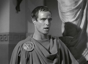 Movie still from “Julius Caesar” (1953), directed by Joseph L. Mankiewicz – A man in a toga with a coin on his shoulder; Close Up shot, Over the shoulder angle