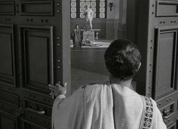 Movie still from “Julius Caesar” (1953), directed by Joseph L. Mankiewicz – A man wearing a toga standing in front of an altar; Wide shot, Over the shoulder angle