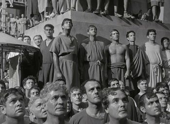 Movie still from “Julius Caesar” (1953), directed by Joseph L. Mankiewicz – A black and white photo of a group of men in roman garb; Wide shot, High angle