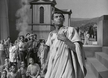 Movie still from “Julius Caesar” (1953), directed by Joseph L. Mankiewicz – A black - and - white photo of a man standing in front of a group of people; Medium shot, Low angle
