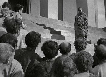 Movie still from “Julius Caesar” (1953), directed by Joseph L. Mankiewicz – A group of people standing on steps in front of a building; Wide shot, Low angle