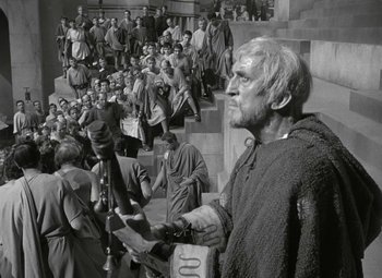 Movie still from “Julius Caesar” (1953), directed by Joseph L. Mankiewicz – An old photo of a man standing in front of a crowd; Wide shot, High angle