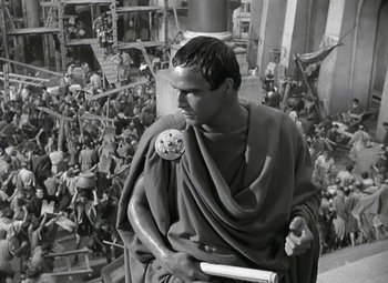 Movie still from “Julius Caesar” (1953), directed by Joseph L. Mankiewicz – A man dressed as a roman soldier in a crowd of people; Medium shot, High angle