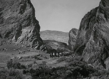 Movie still from “Julius Caesar” (1953), directed by Joseph L. Mankiewicz – A black and white photo of people on horseback in the mountains; Extreme Wide shot, High angle